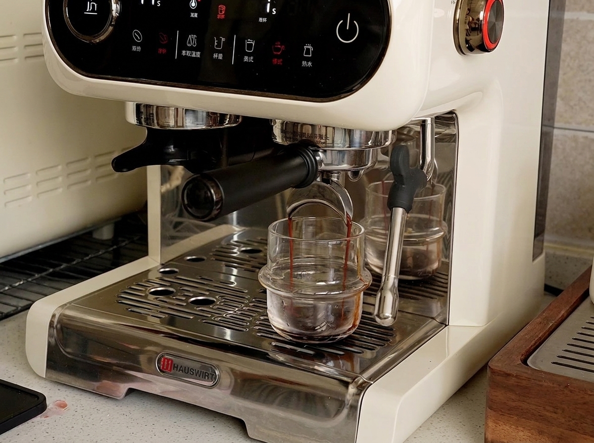Una máquina de espresso dispensando líquido oscuro de espresso en una pequeña taza de vidrio en la bandeja de goteo.