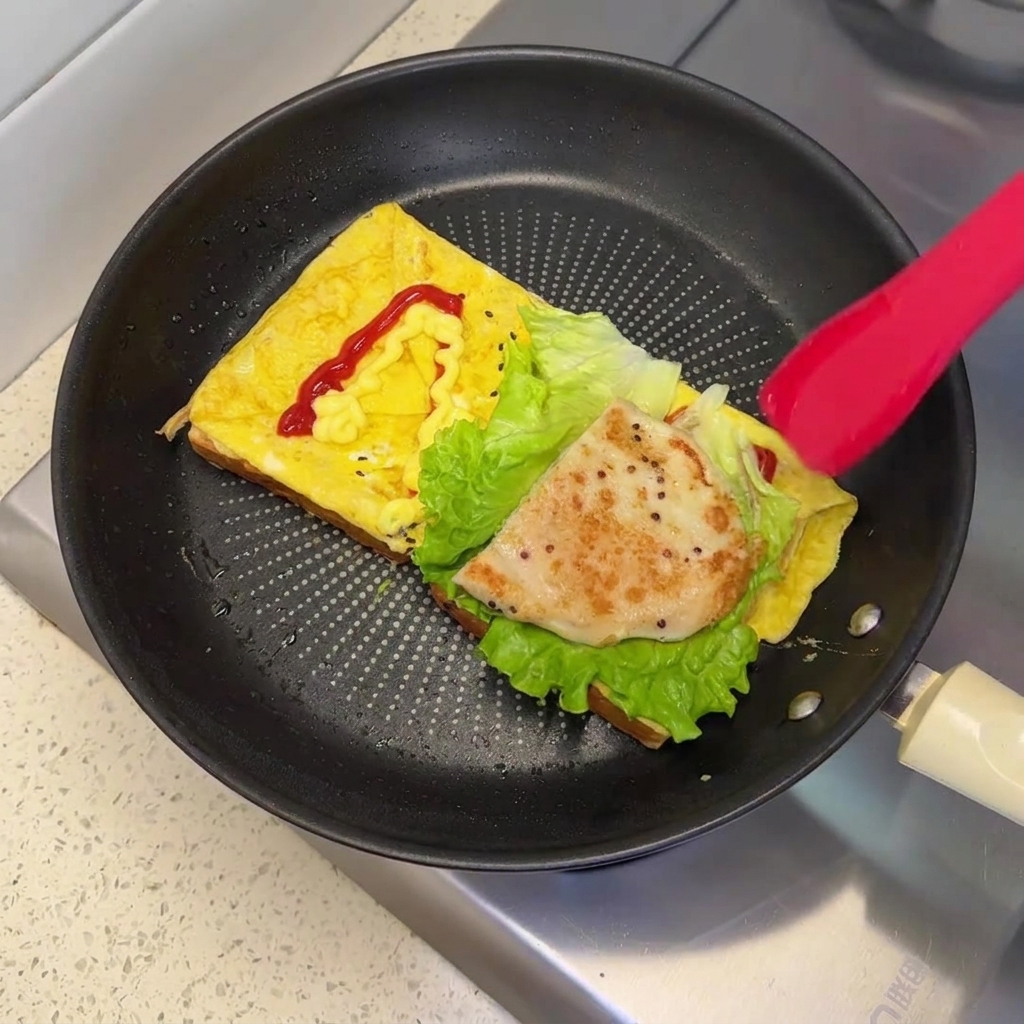 Una croqueta de pollo frita en sartén de tono marrón dorado colocada sobre la lechuga fresca dentro del sartén.