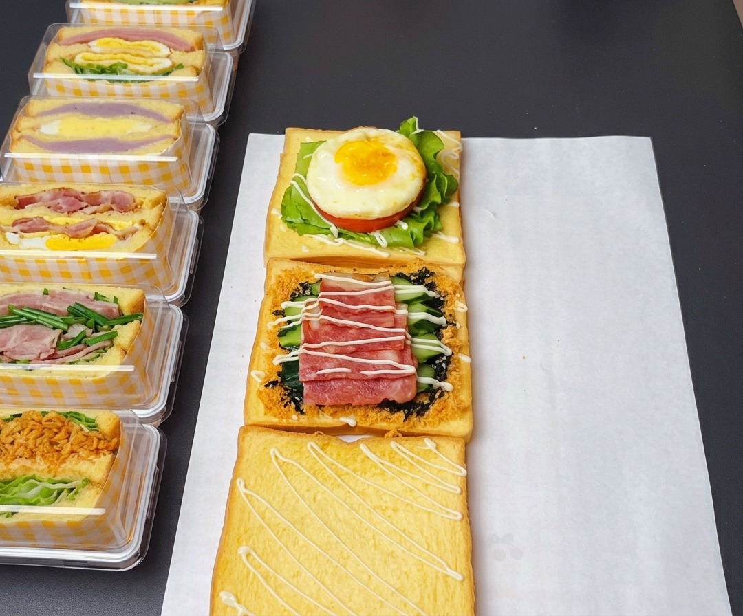 Las capas del sándwich ensambladas con aderezo de ensalada dulce, ketchup en el huevo y salsa de mostaza y miel en el tocino.