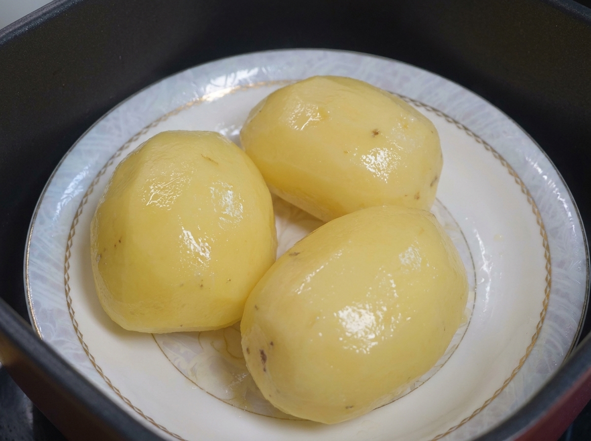 Papas al vapor en un plato listas para ser cubiertas con aceite.