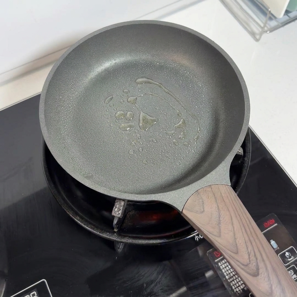 Una sartén antiadherente con aceite rociado en el fondo, lista para cocinar.