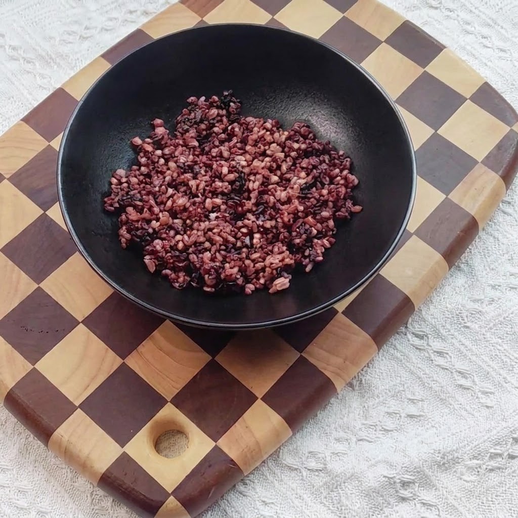 Arroz negro cocido colocado dentro de un bol de servicio negro.