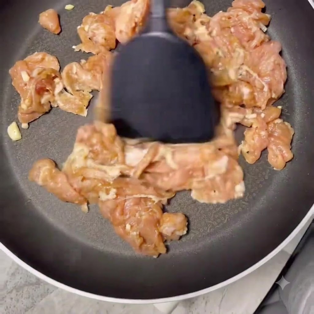 Trocitos de cerdo cocinándose en una sartén seca hasta dorarse y quedar sin líquido.