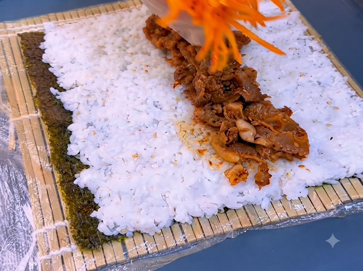 Zanahorias ralladas sobre una tira de ternera asada sazonada encima de una base de arroz blanco.