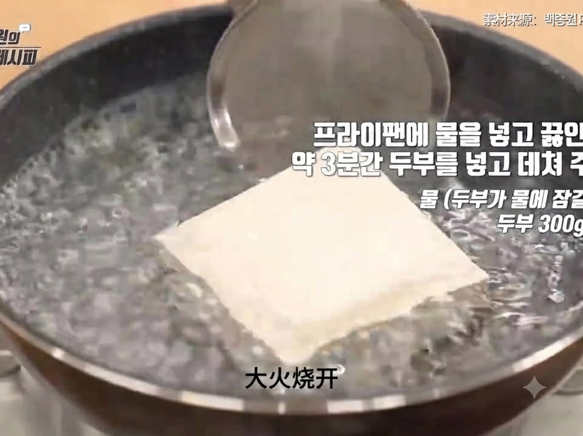 Un bloque de tofu firme sumergido en una olla con agua hirviendo vigorosamente durante el proceso de escaldado.