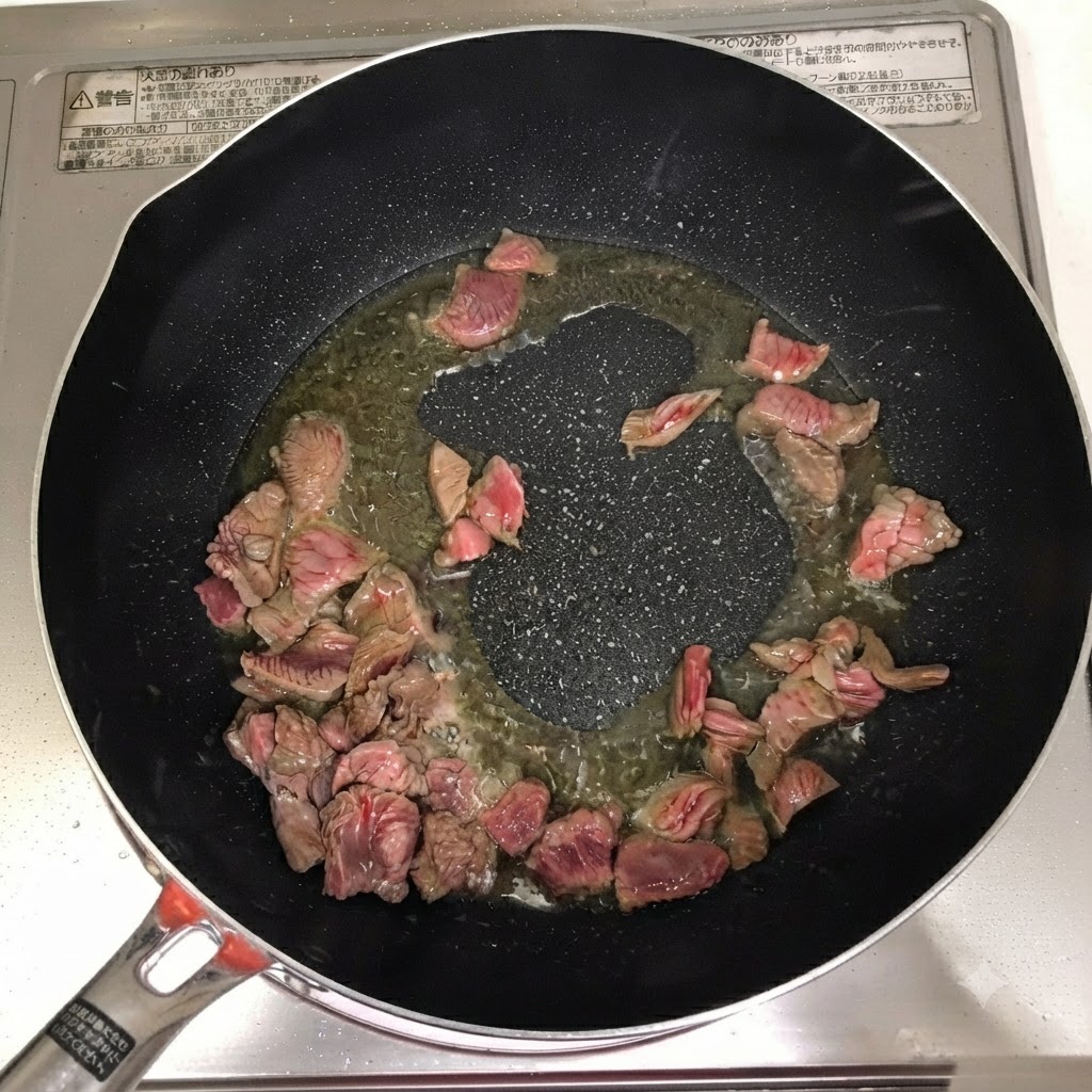 Vino de cocina, chili en polvo y pasta de ají añadidos sobre la ternera en la sartén.