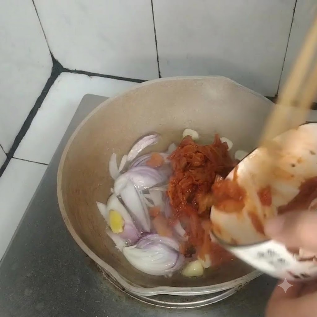 Kimchi vertido desde un tazón pequeño a una sartén que contiene cebollas, ajo y jengibre salteados.