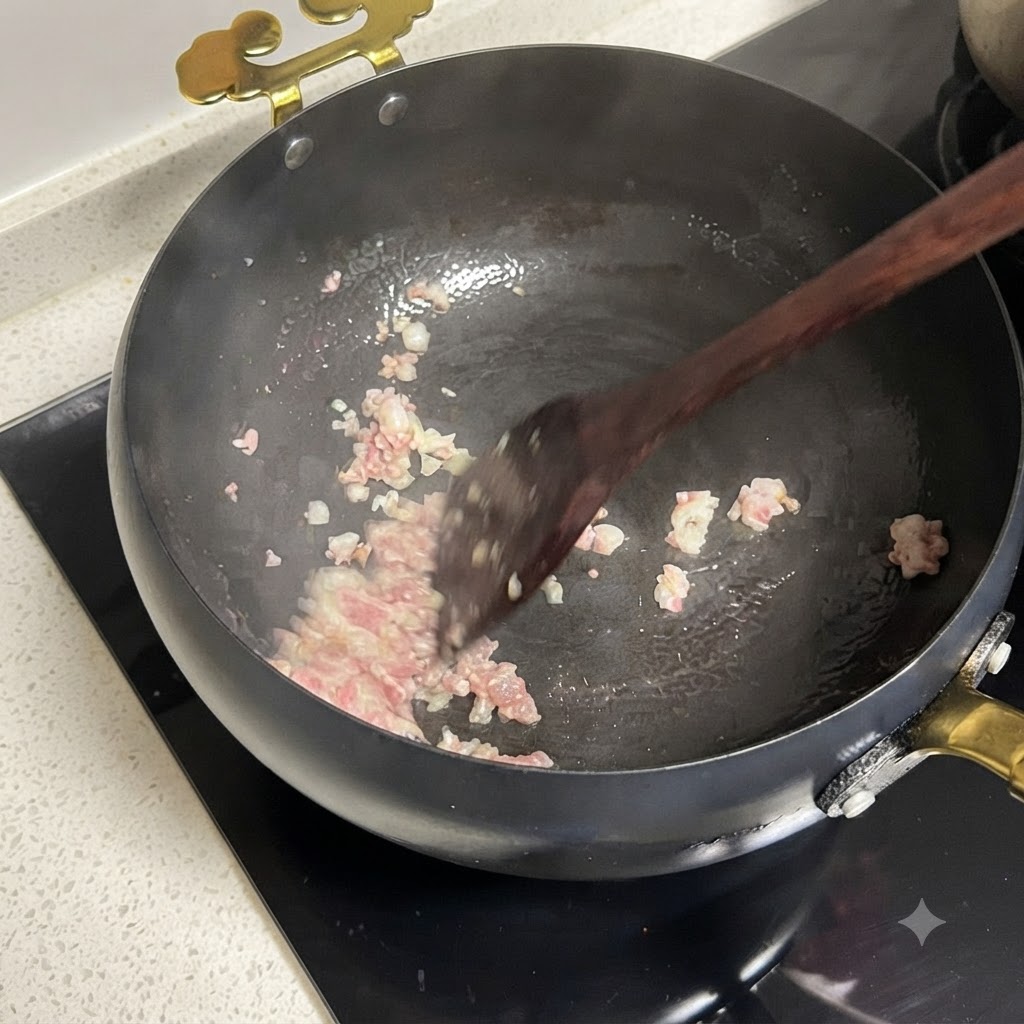 Cebollas rojas en dados y tomates picados cocinándose juntos en una sartén.