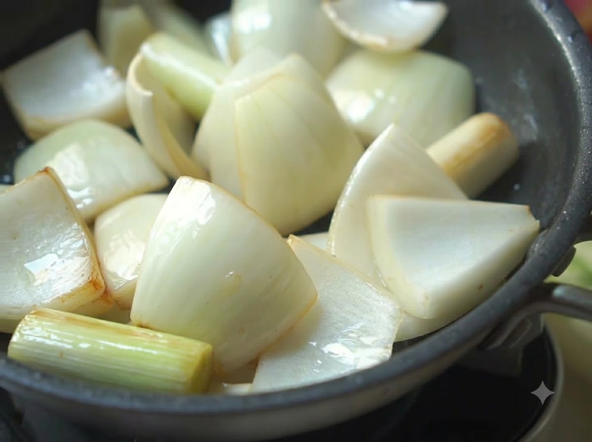 Cebollas, cebollinos y pimientos verdes chisporroteando en una sartén con aceite.