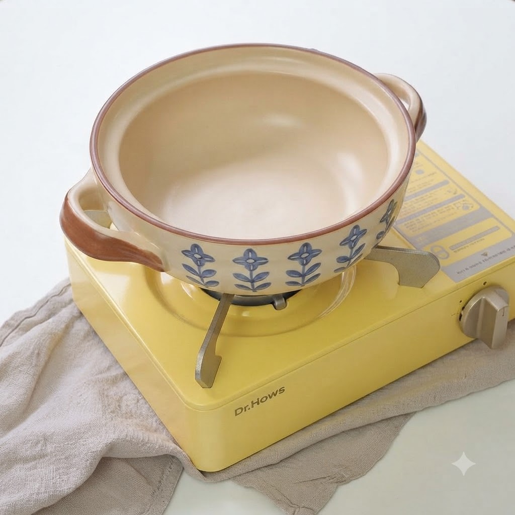 Cebollines y ajo en rodajas chisporroteando en una olla de cerámica con aceite.
