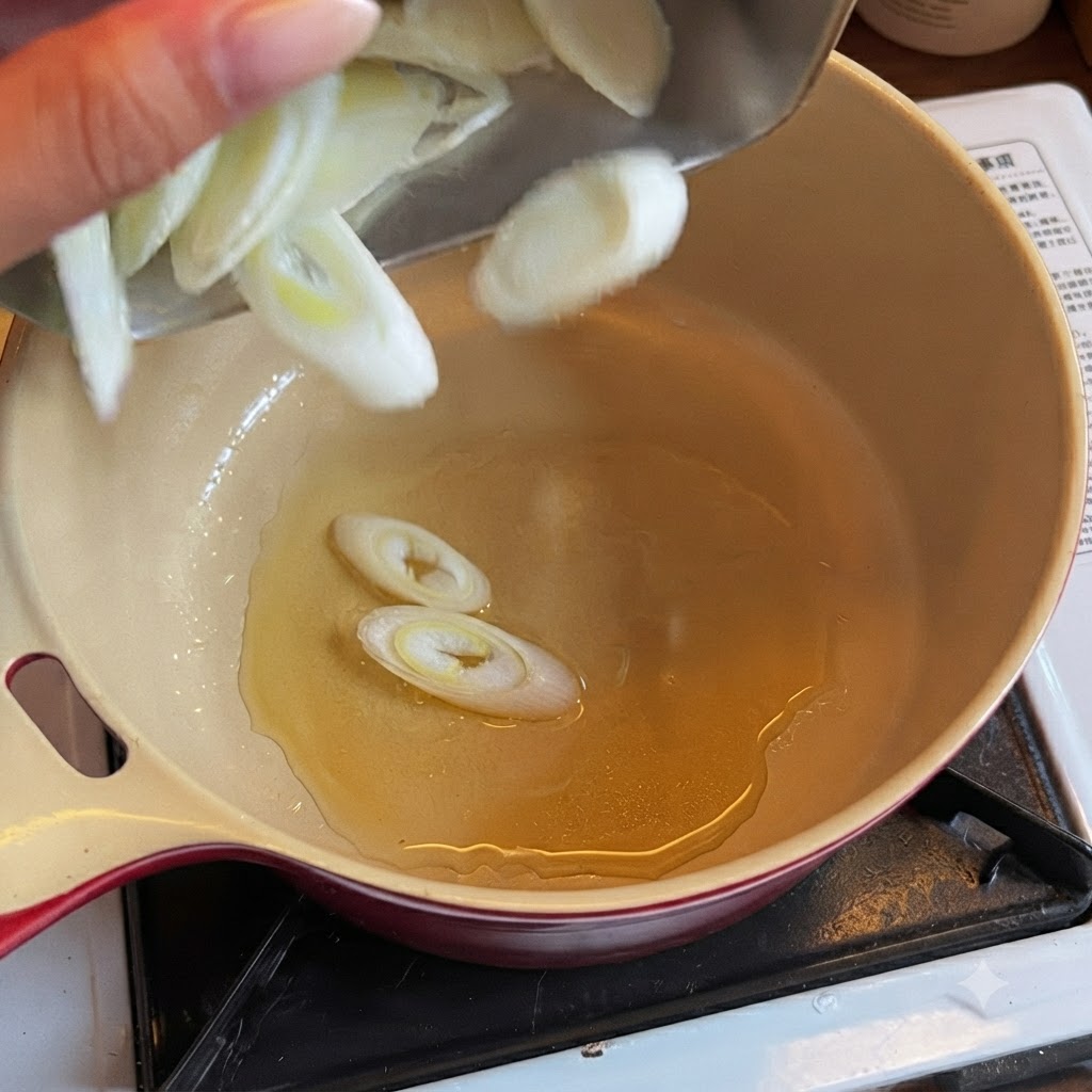Cebolletas en rodajas cayendo en una olla con aceite caliente.