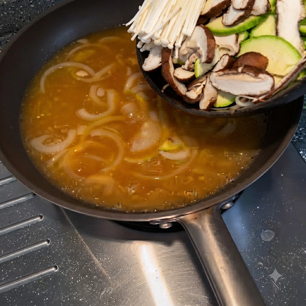 Un plato de calabacín cortado, setas enoki y setas shiitake siendo vertido en una sartén con caldo sazonado.