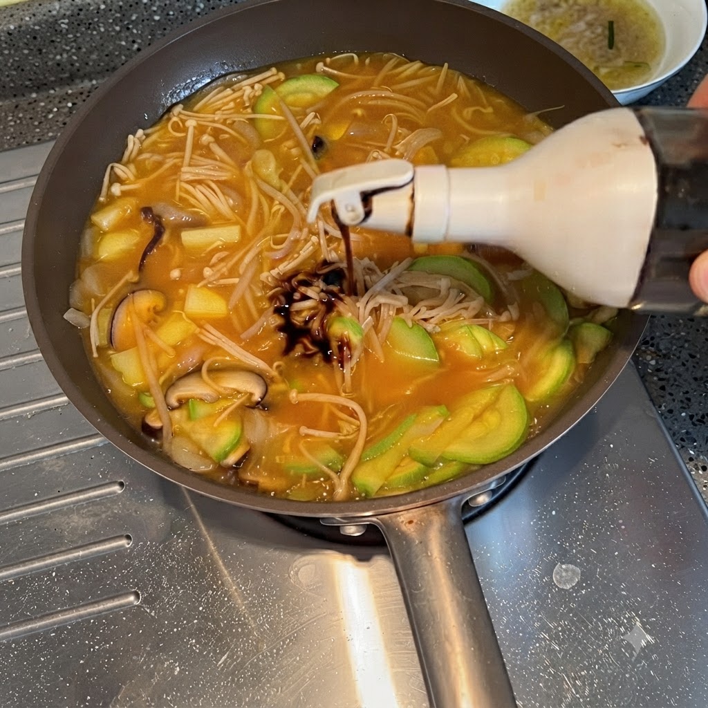 Salsa de soja siendo exprimida desde una botella en el estofado de verduras hirviendo a fuego lento.