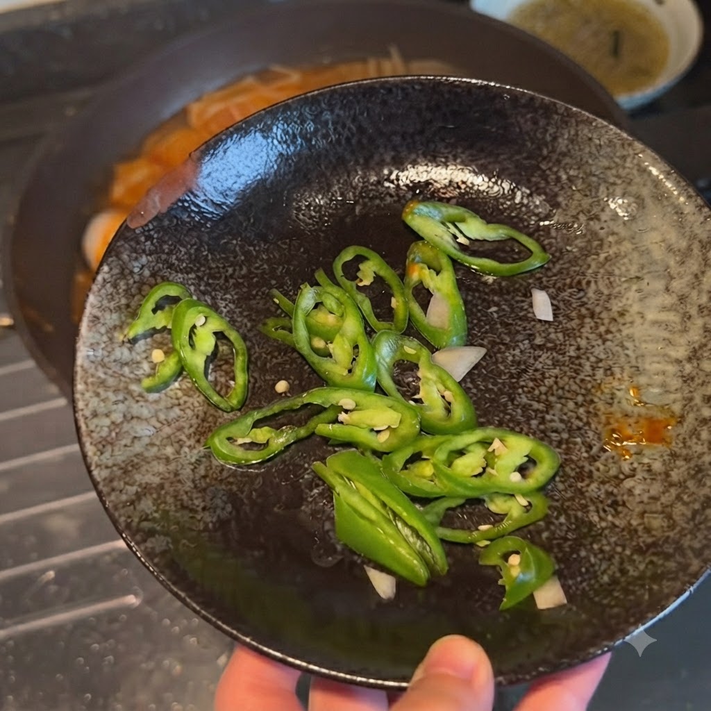Chiles verdes cortados mostrados en un plato decorativo oscuro antes de ser añadidos al plato.