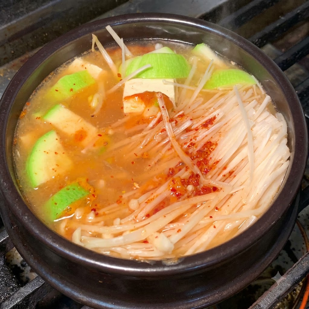 Un primer plano de la olla de barro con ingredientes hirviendo a fuego lento en un caldo sazonado.