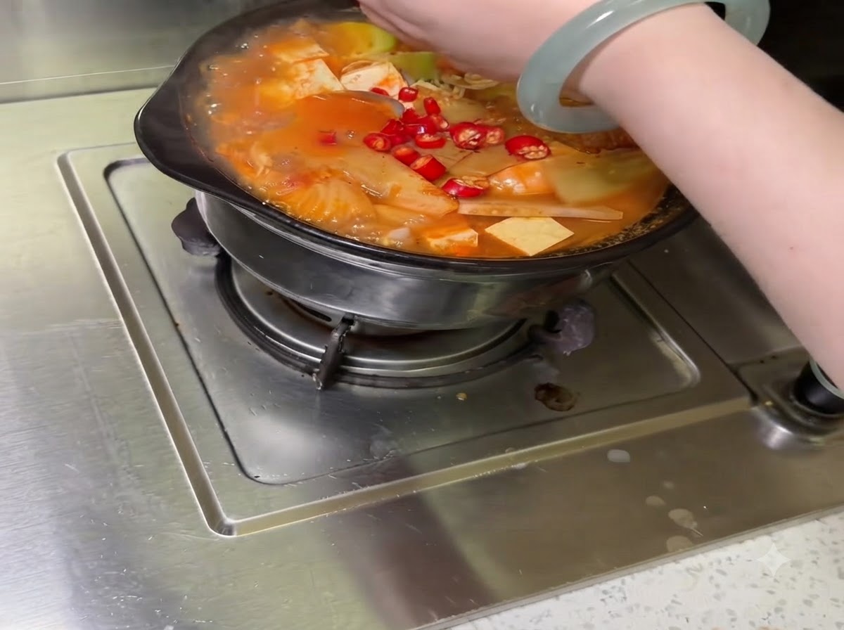 Verduras cortadas surtidas y chiles dispuestos dentro de la olla de cocción.