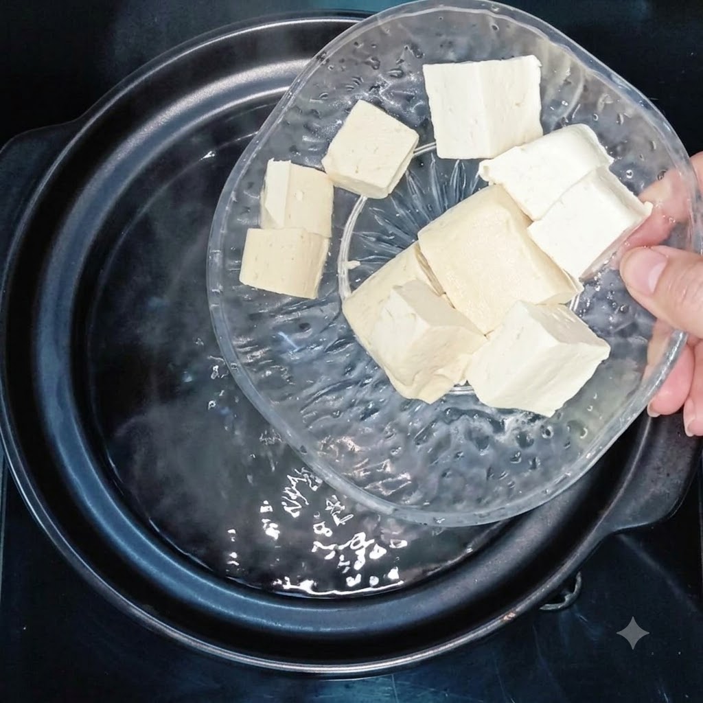 Cubos de tofu siendo agregados a una olla con agua hirviendo.