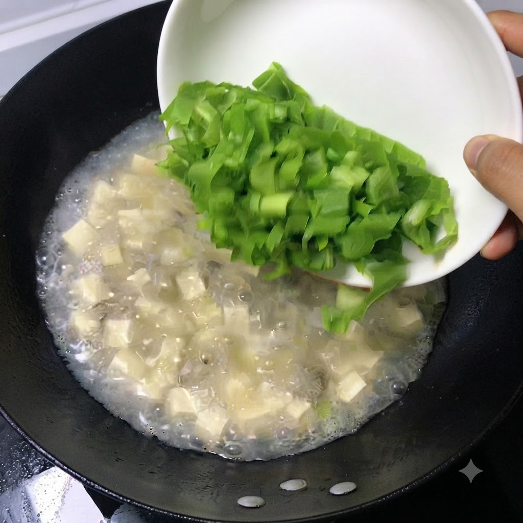 Hojas verdes frescas picadas deslizándose desde un plato blanco hacia una olla hirviendo de sopa.