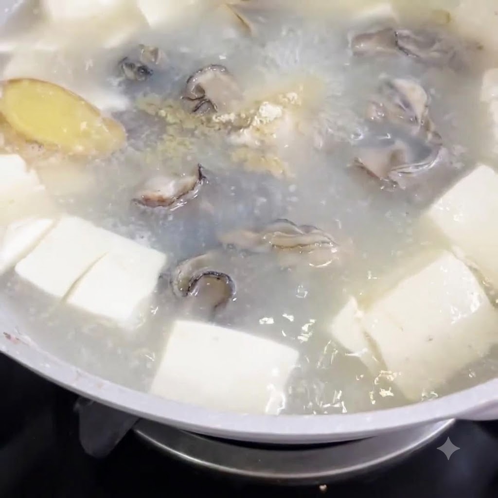 Pimienta blanca en polvo siendo espolvoreada en una olla de sopa hirviendo con cubos de tofu y ostras.