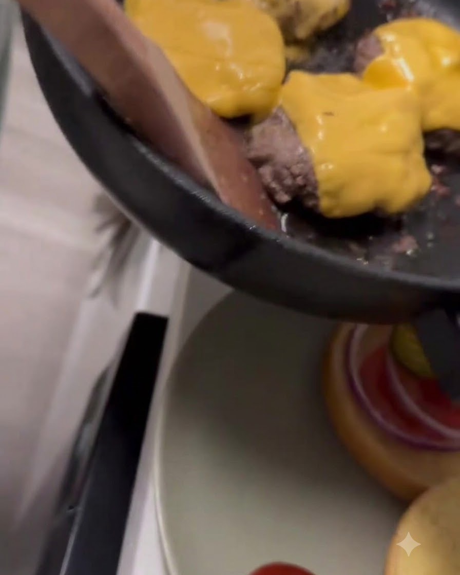 Queso cheddar amarillo derritiéndose sobre las hamburguesas de ternera dentro de una sartén.