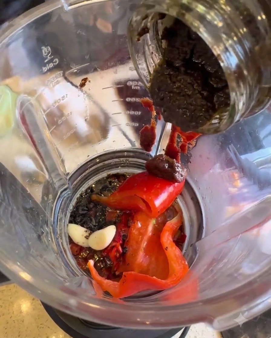 Pasta de trufa negra siendo transferida desde un tarro a la licuadora.