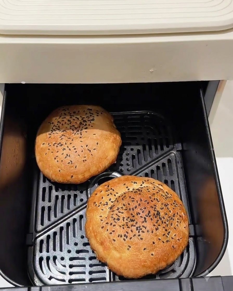 Panes de hamburguesa horneados dentro de la cesta de una freidora de aire.