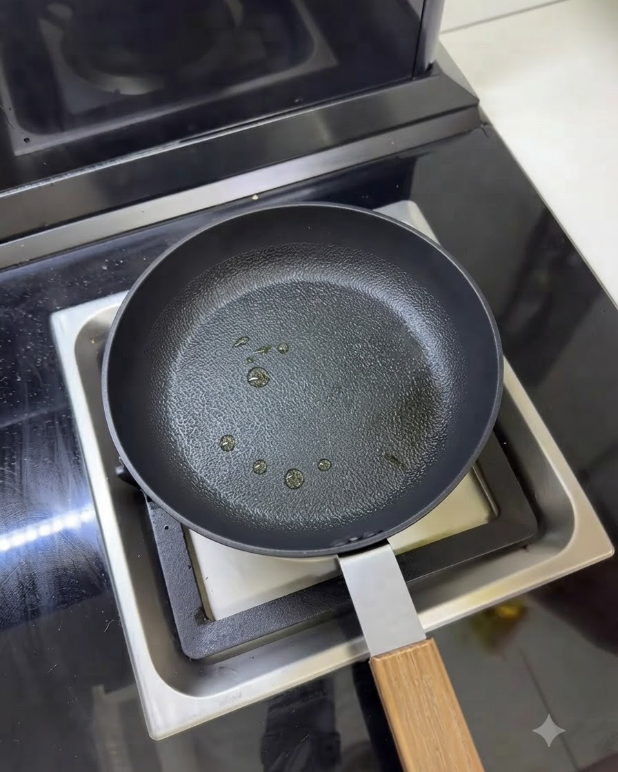 Una sartén con varias gotas pequeñas de aceite de cocina rociadas en la superficie.