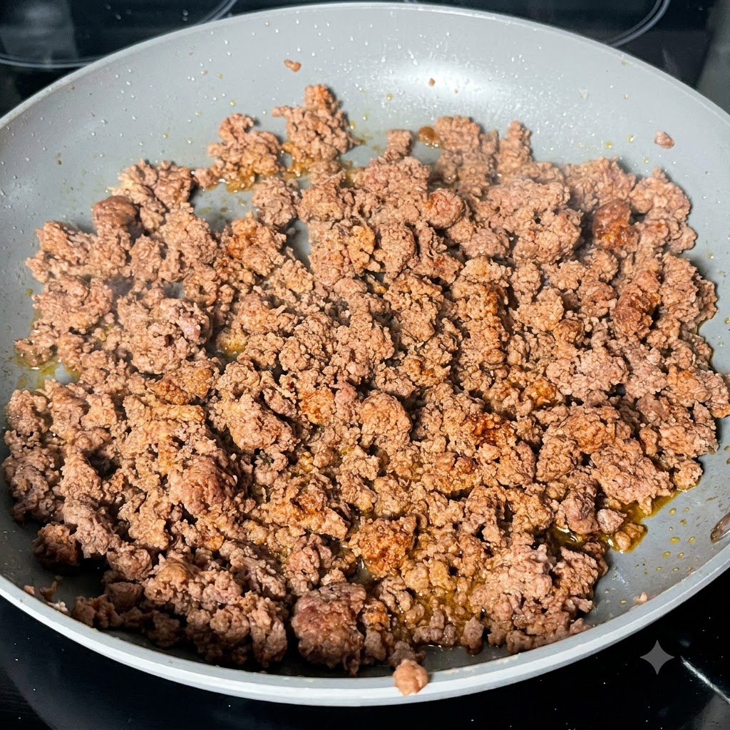 Salsa Worcestershire oscura siendo vertida sobre la carne picada dorada en una sartén.