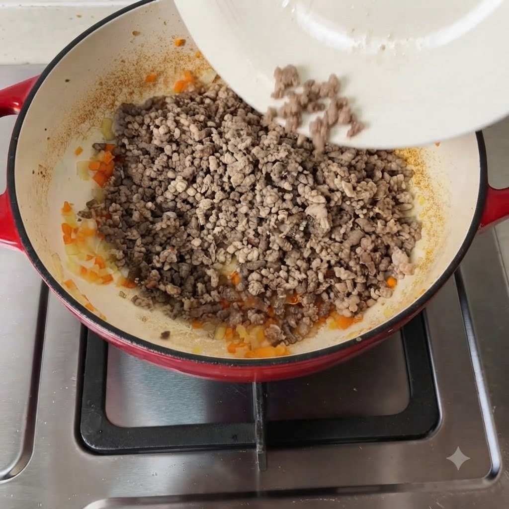 Diversos condimentos y tomates picados siendo añadidos a la mezcla de carne y verduras.