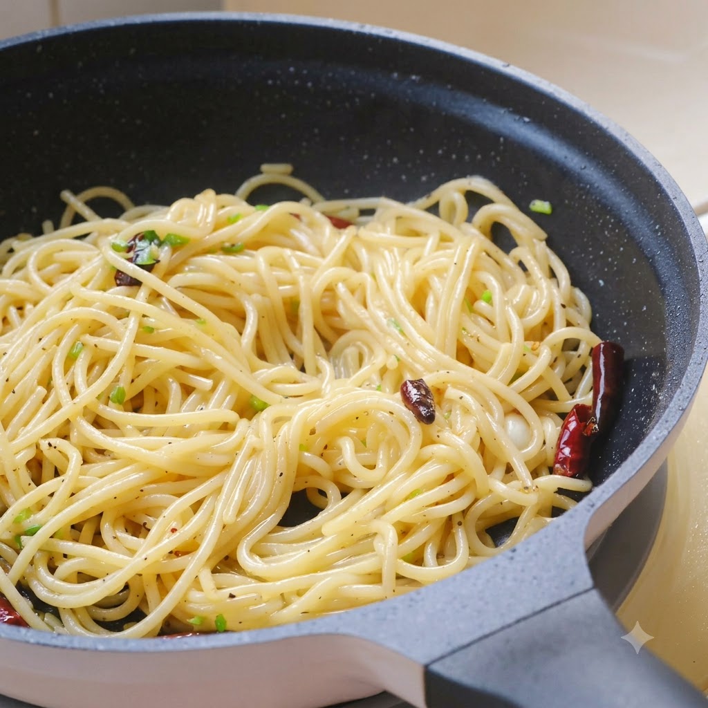 Hojas de cilantro fresco picadas, sal marina y pimienta negra espolvoreadas sobre la pasta en la sartén.