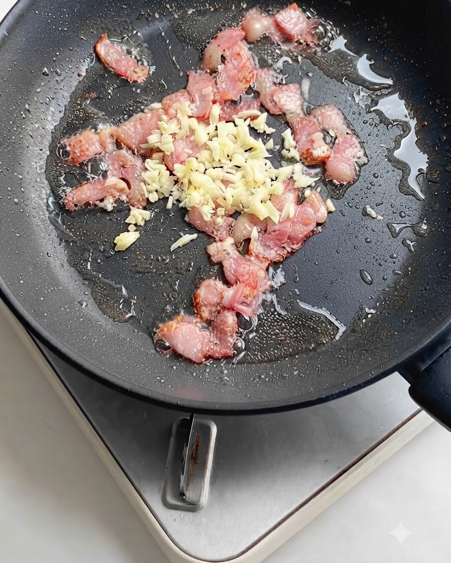Rodajas de chile rojo brillante agregadas a la sartén con tocino chispeante y ajo.