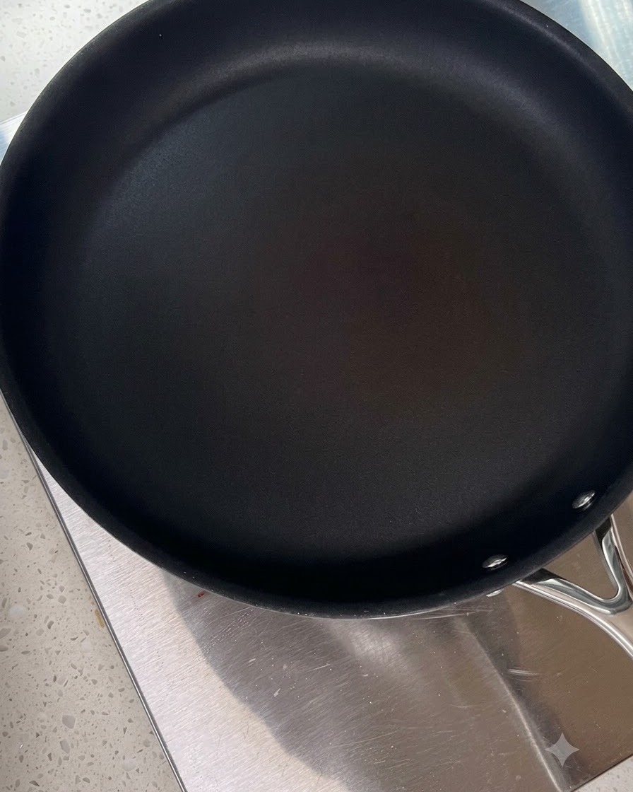 Una sartén negra limpia calentándose en una estufa.