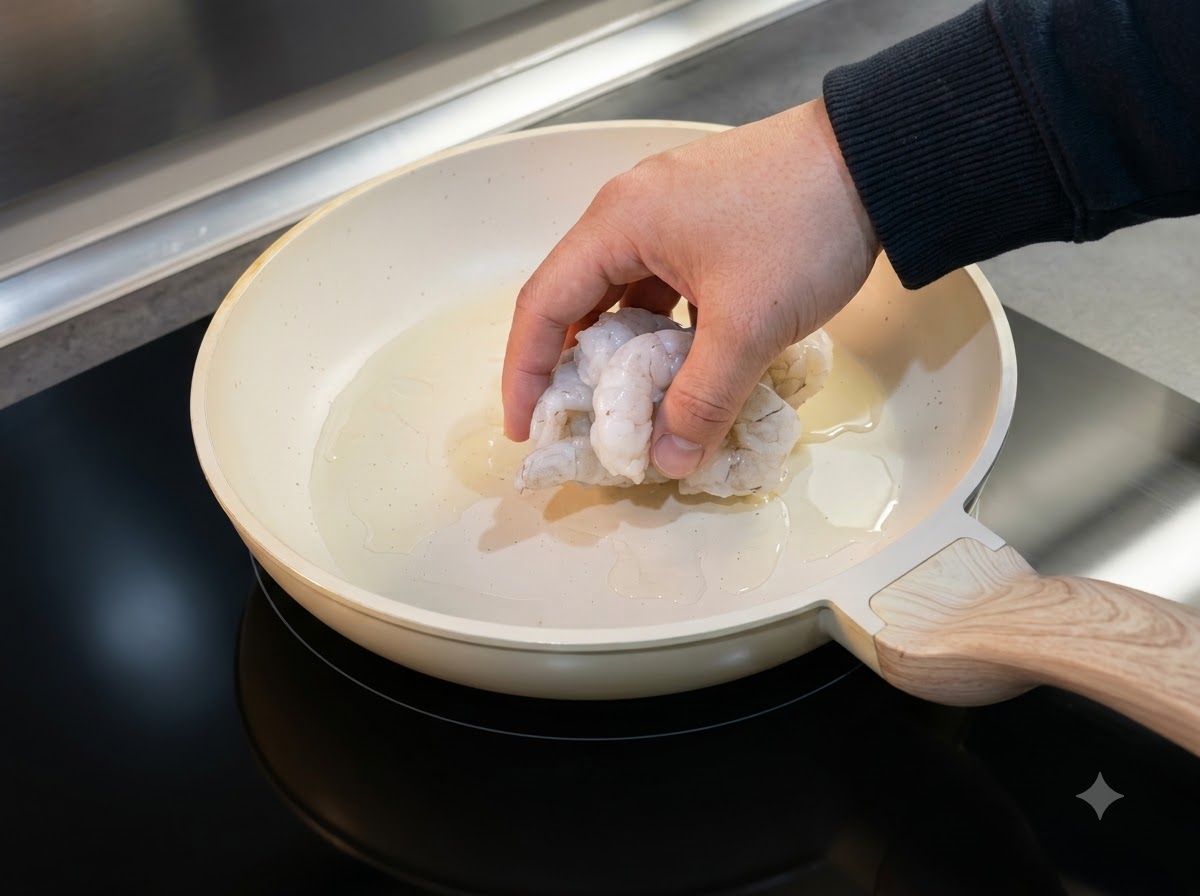 Camarones descongelados colocados en una sartén con aceite para cocinar.