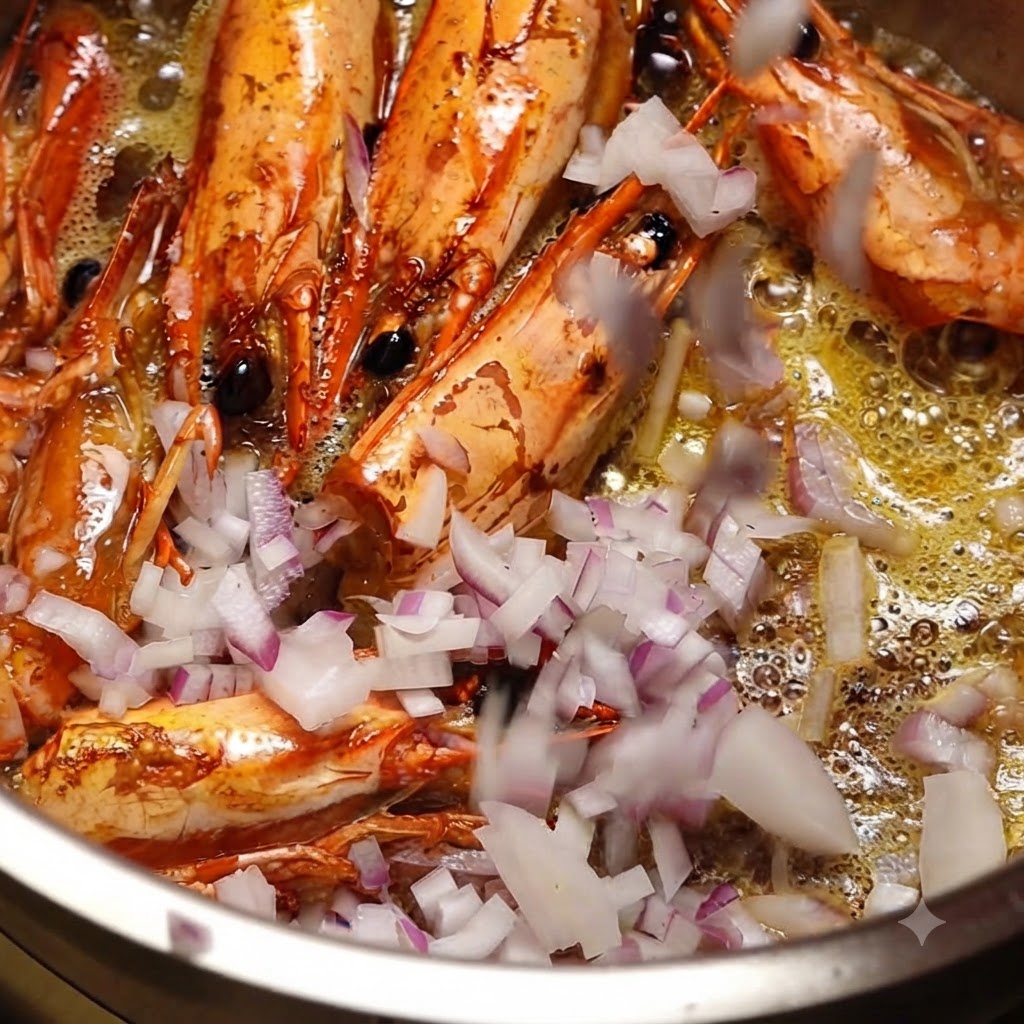 Cebollas rojas picadas finamente siendo agregadas a una olla que contiene cabezas de camarón frito y aceite caliente.