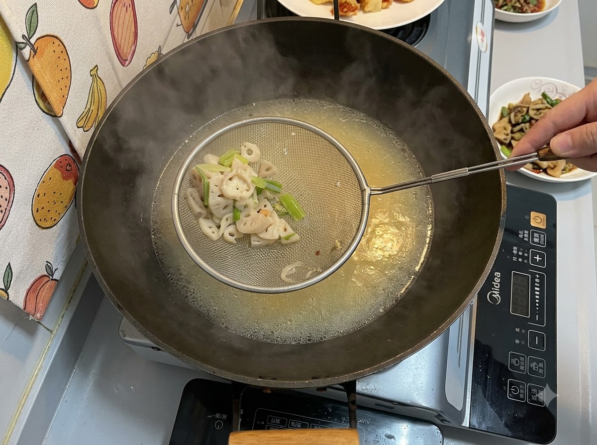 Una espumadera de metal sosteniendo trozos sólidos colados sobre un wok lleno de un caldo cremoso amarillento hirviendo a fuego lento.
