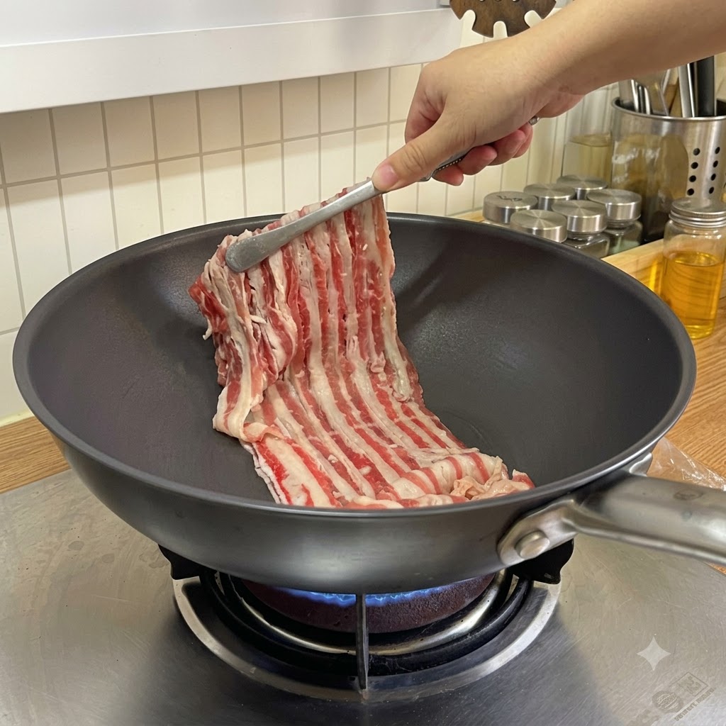 Tiras de ternera finamente cortadas colocándose en una sartén caliente con unas pinzas.