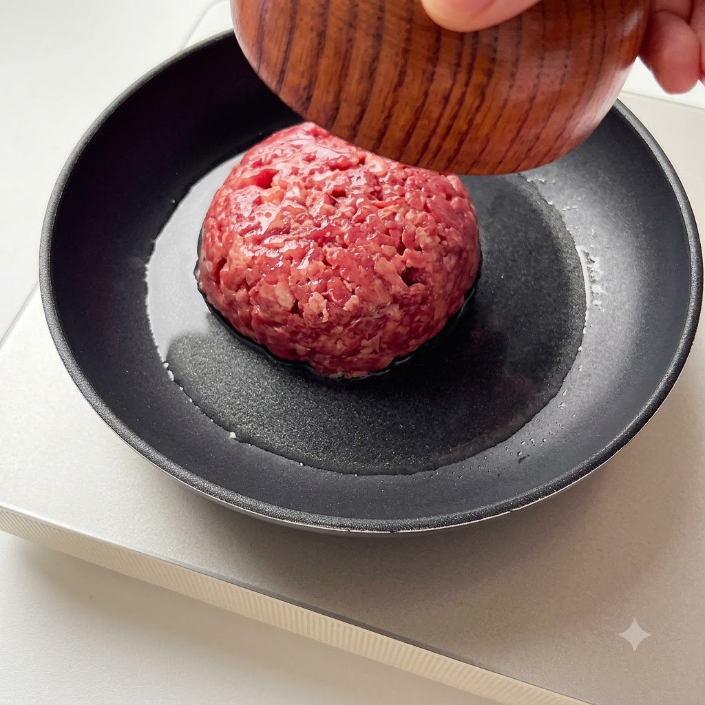 Carne molida siendo añadida a una sartén caliente.