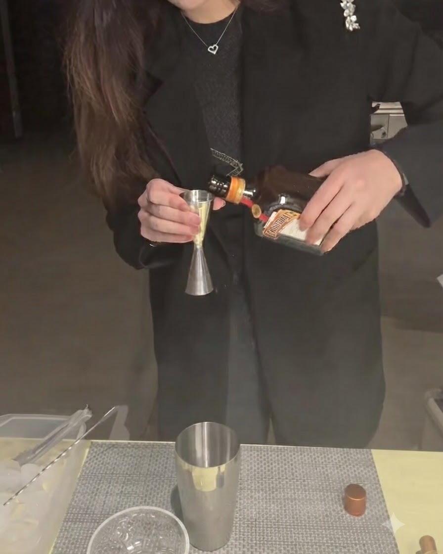 Cointreau siendo vertido en un medidor con una coctelera debajo.