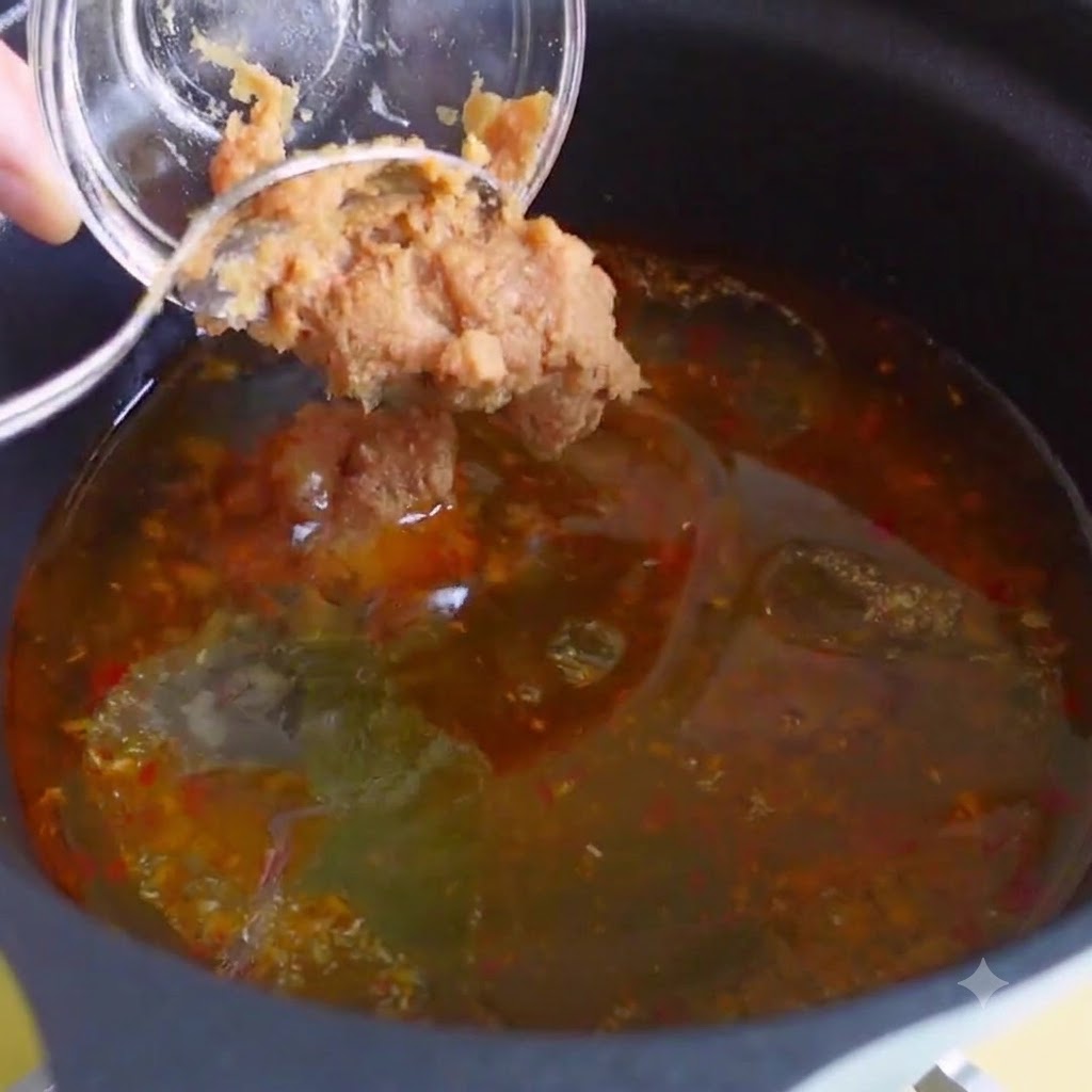Consomé de pollo, extracto de bonito y pasta de chile coreano mezclados en el caldo de sopa.
