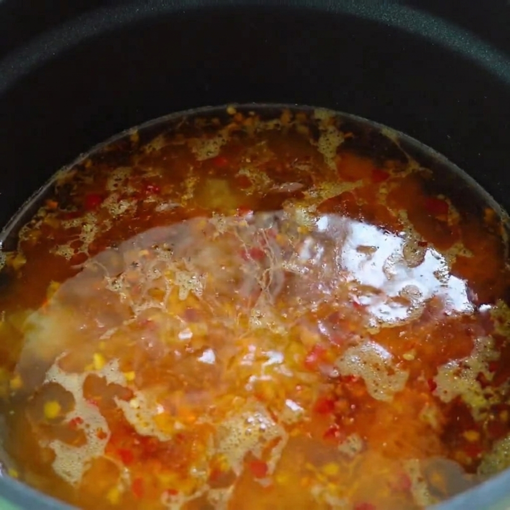 Aceite de chile y aceite de sésamo rociados en la superficie de la base de sopa caliente.