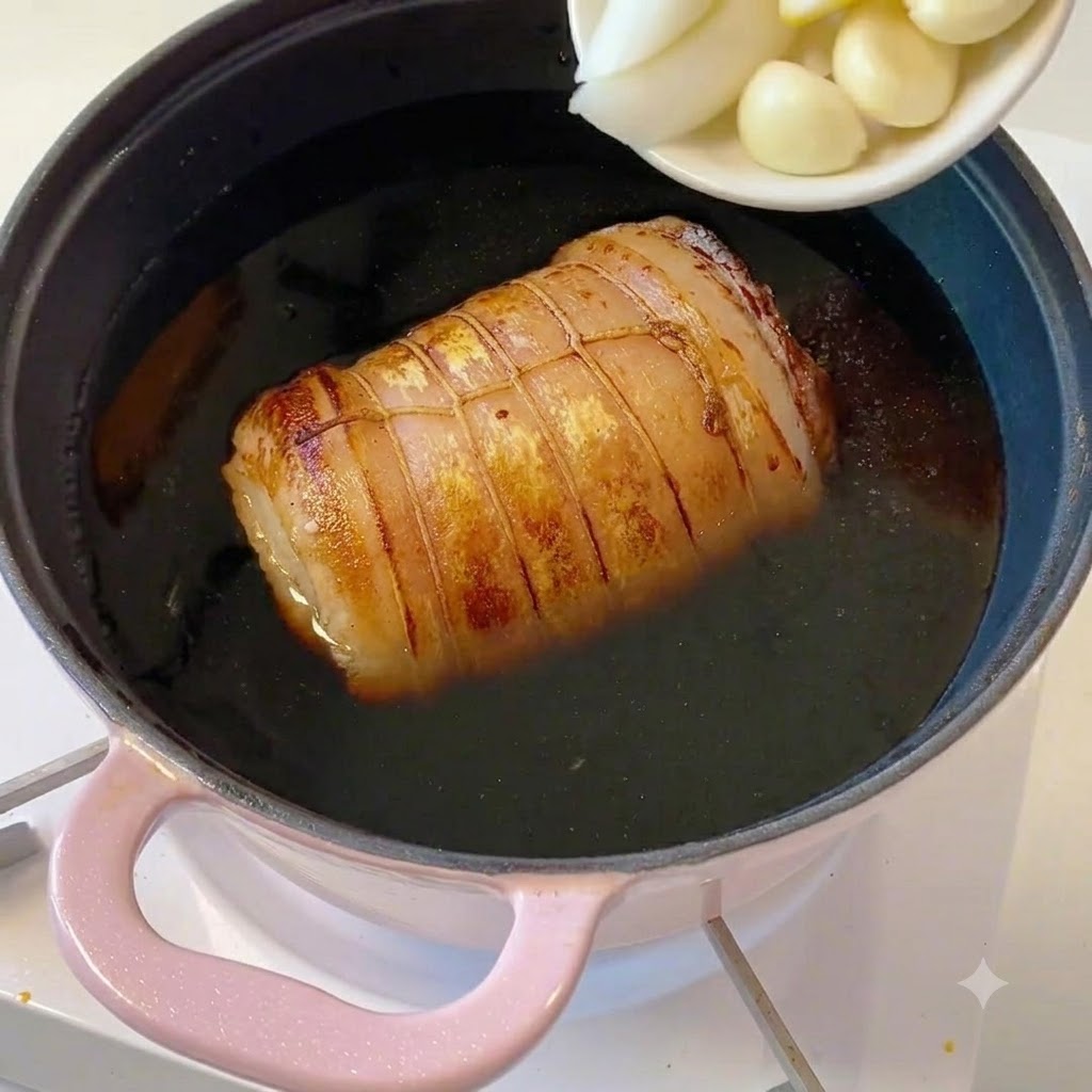 Un pequeño plato blanco con cebolletas en rodajas, trozos de jengibre y dientes de ajo vaciándose en la olla.