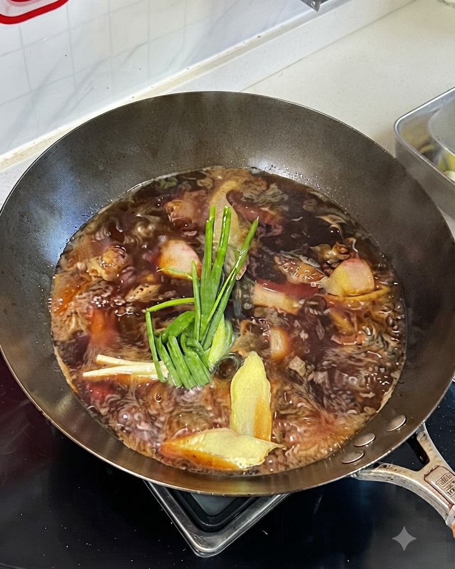 Líquido de estofado burbujeando en un wok con cebollinos, jengibre y especias encima de la carne.