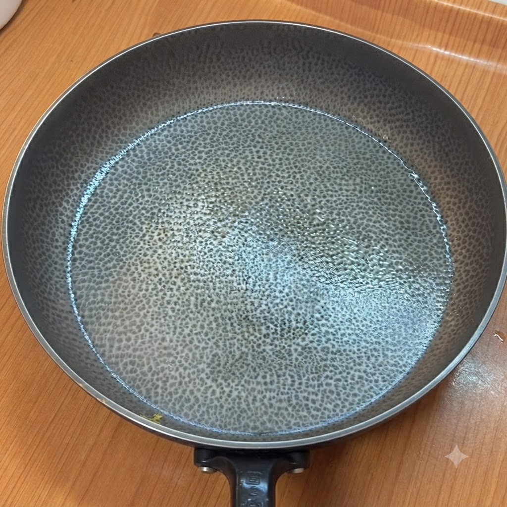 Un sartén vacío y caliente con una superficie texturizada en una encimera de cocina.