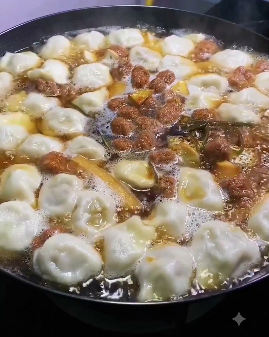 Sal siendo esparcida uniformemente sobre la parte superior de una olla burbujeante de sopa y dumplings.