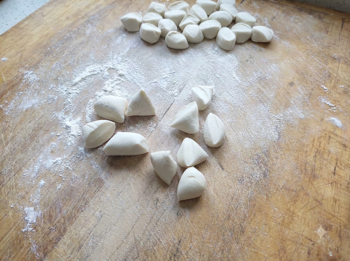 Pequeños trozos de masa blanca para dumplings cortados y esparcidos en una tabla de madera enharinada.