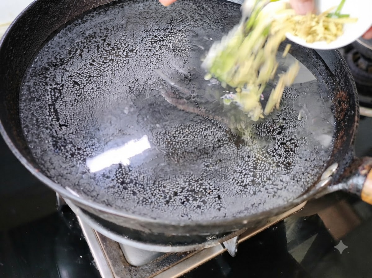 Cebollinos picados y jengibre siendo añadidos a un wok con agua en la estufa.
