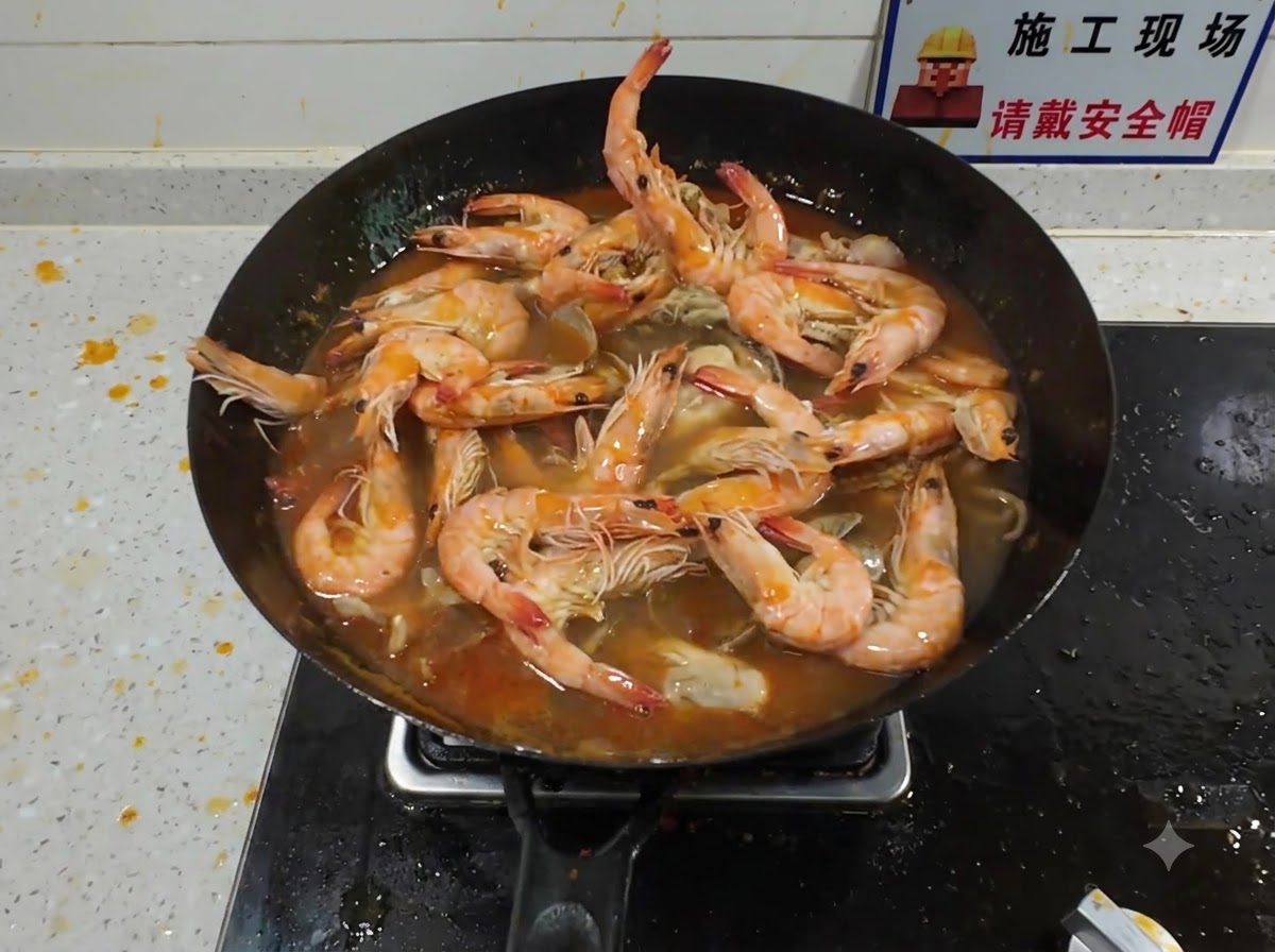 Una langosta grande siendo añadida a un wok abarrotado lleno de mariscos hirviendo y un rico caldo rojo.
