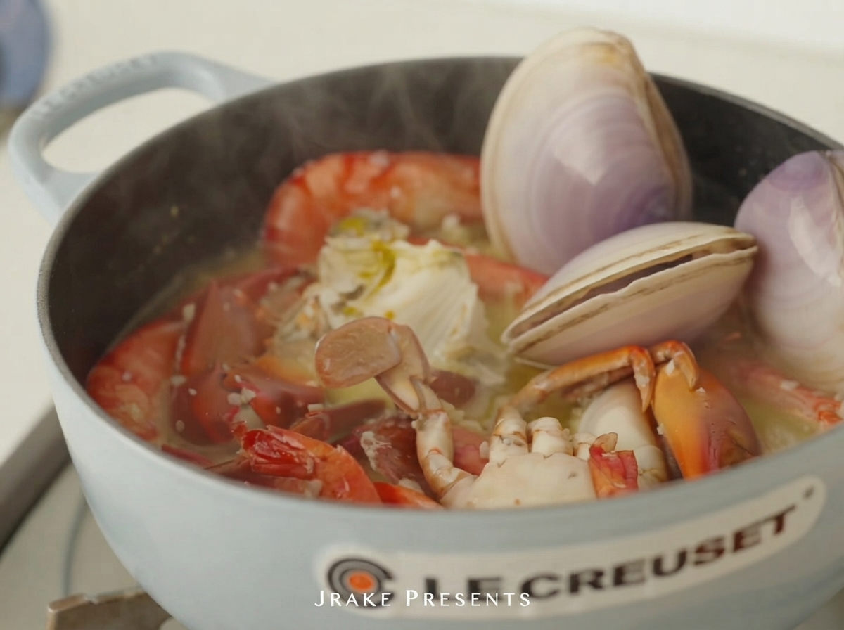 Almejas crudas y abulón colocados en la olla con camarones y cangrejo.