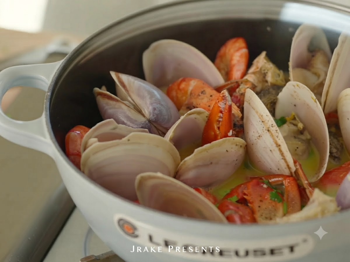 Jugo de limón fresco siendo exprimido sobre la olla de mariscos cocidos.