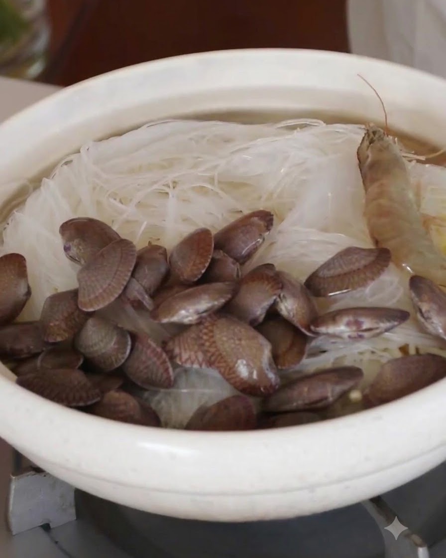 Camarones enteros crudos y almejas frescas organizados en círculo sobre los fideos de cristal.